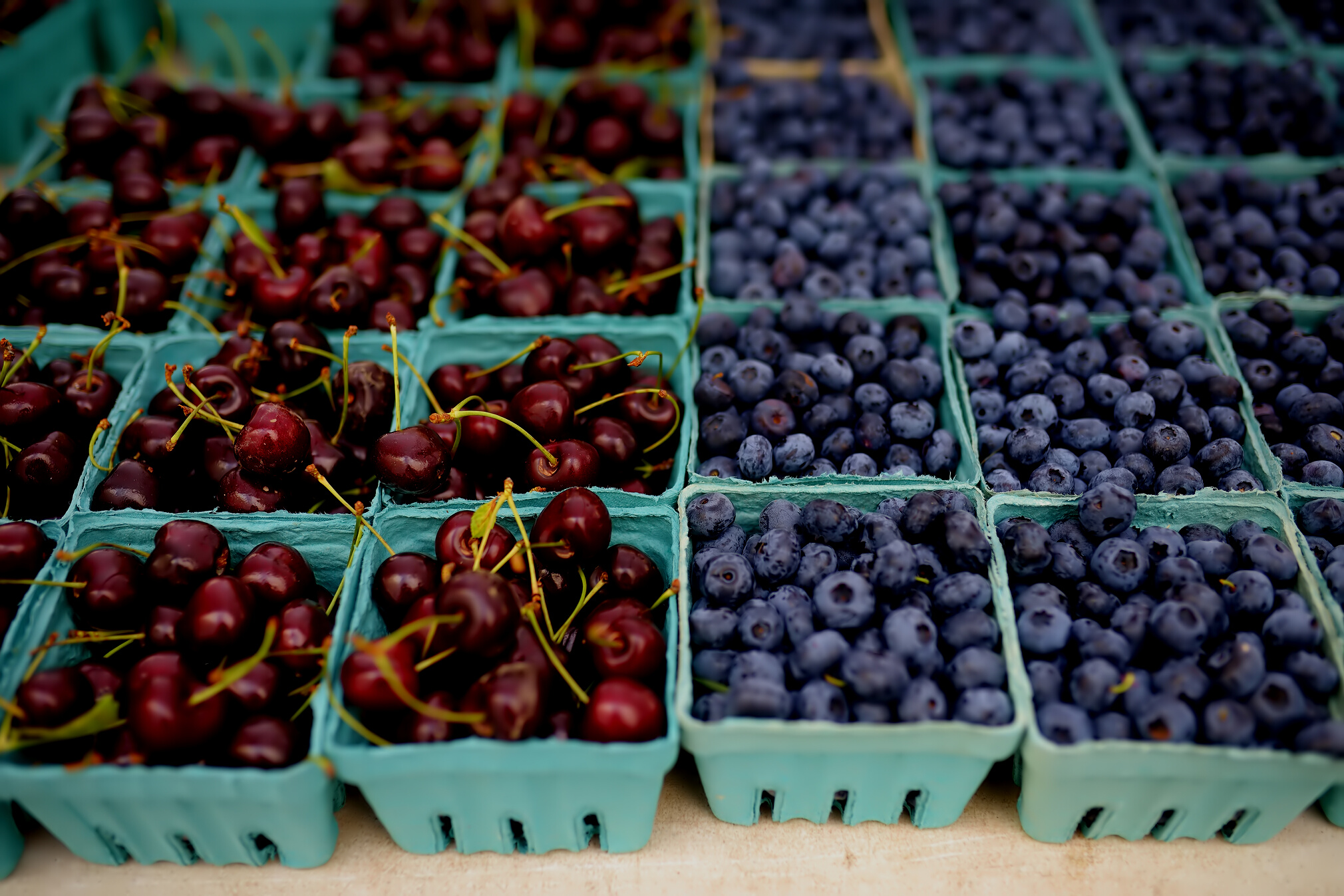 Fresh assorted berries at farmers market. Cherries and blueberries